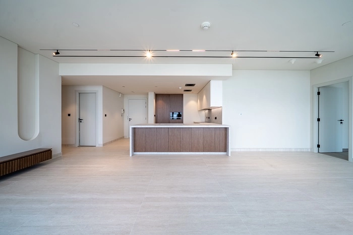 Contemporary Kitchenette with Wood-Paneled Island in a Bright White Apartment