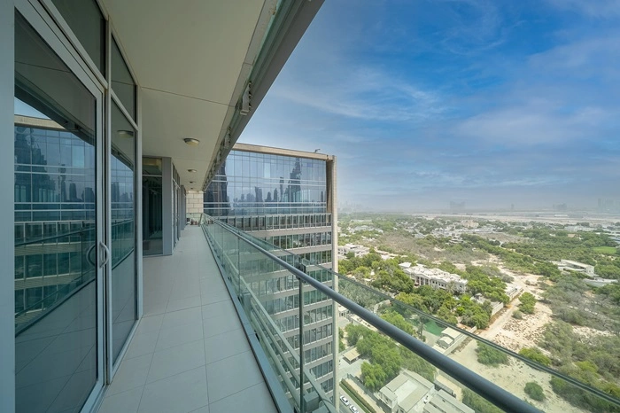 Long High-Rise Balcony with Glass Railing Overlooking Green Landscape and City View